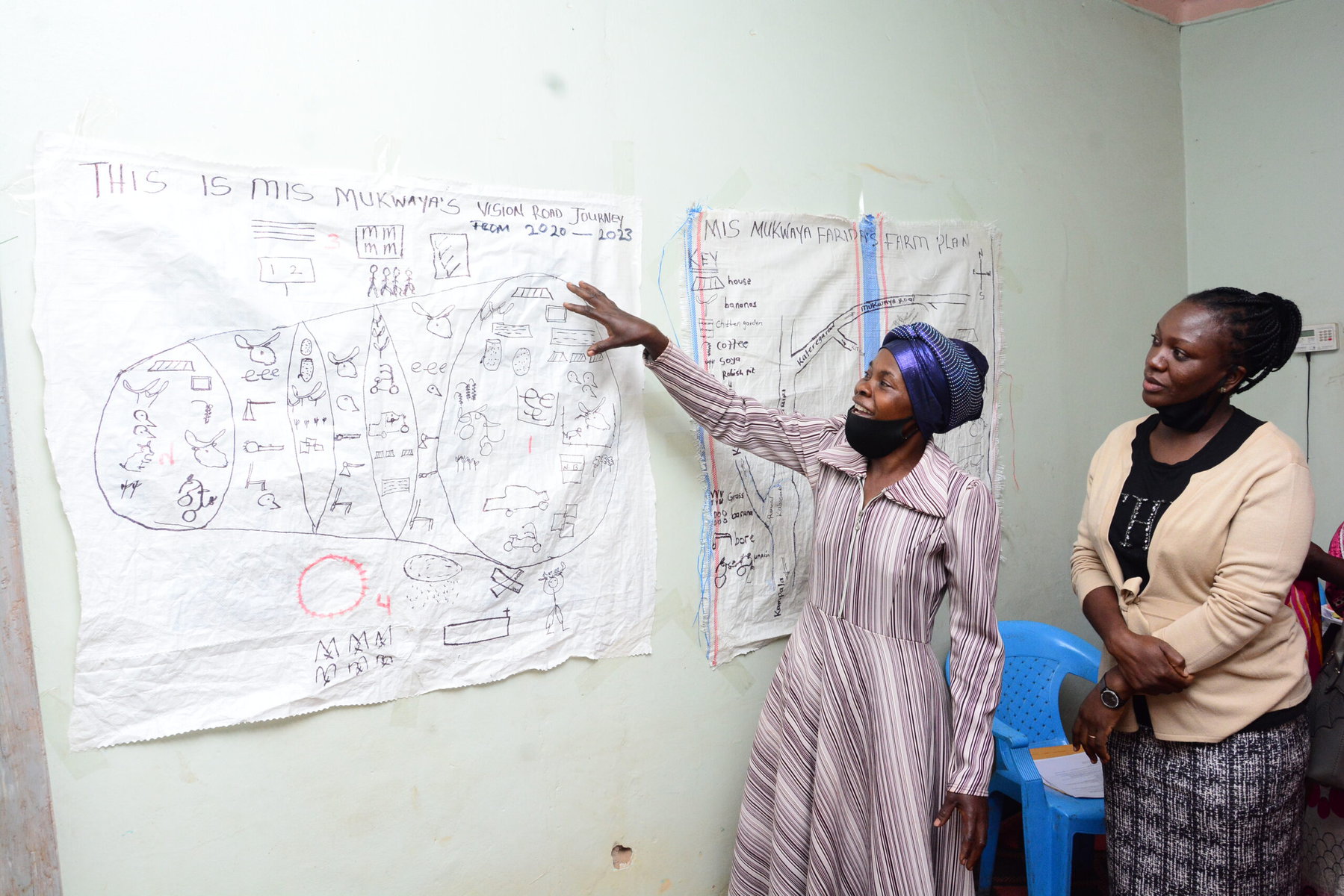 Faridah Nakayiza explains her vision road journey, which she has drawn and hung on a wall.