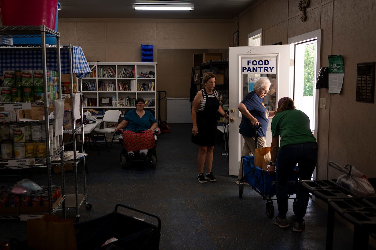 Volunteers and employees at the Leon Community Food Pantry and Clothes Closet in Jewett work together to cart food to a client. 