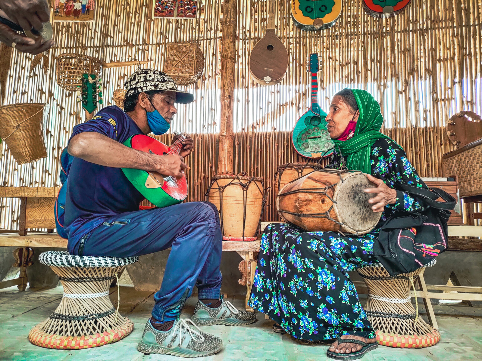 Two Rohingya musicians sing and play instruments.