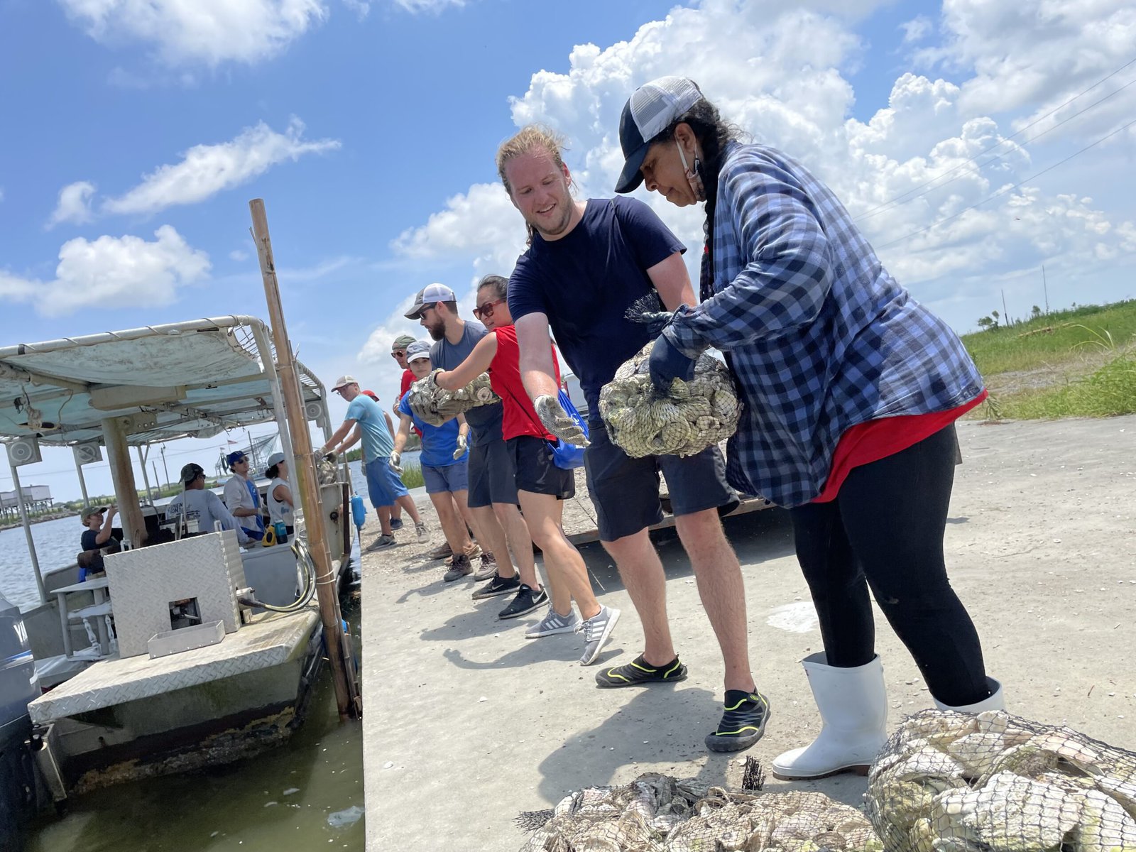 Volunteers pass along bags of oyster shells.