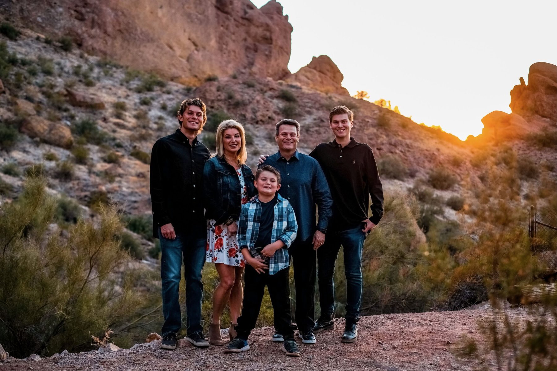 The Garcia family poses in front of a rocky landscape in Arizona.
