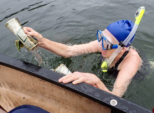 A member of Old Ladies Against Underwater Garbage holds a beer can found during a pond cleanup.