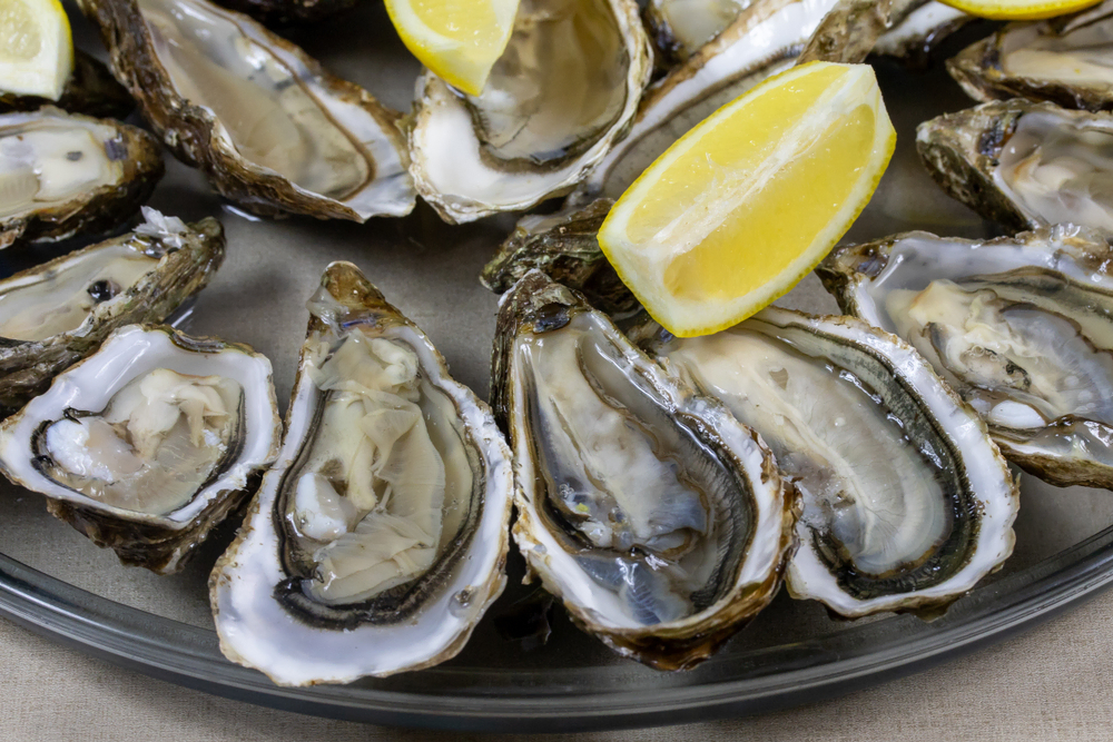 A platter of oysters with lemon.