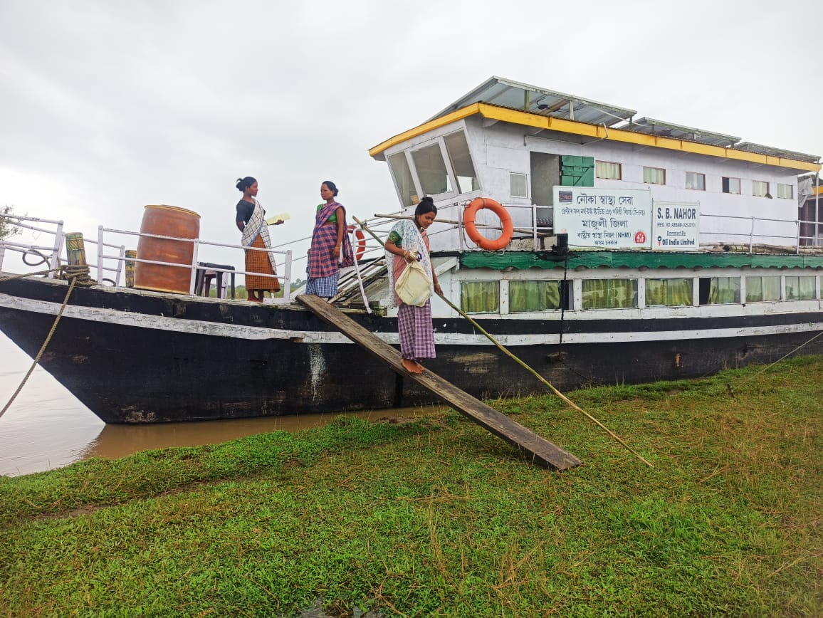 A pregnant woman slowly climbs down from the boat clinic after her checkup. 