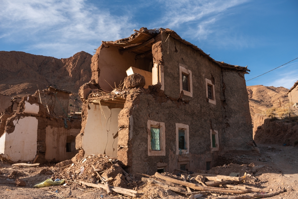 A house has been damaged, with walls missing, due to an earthquake.