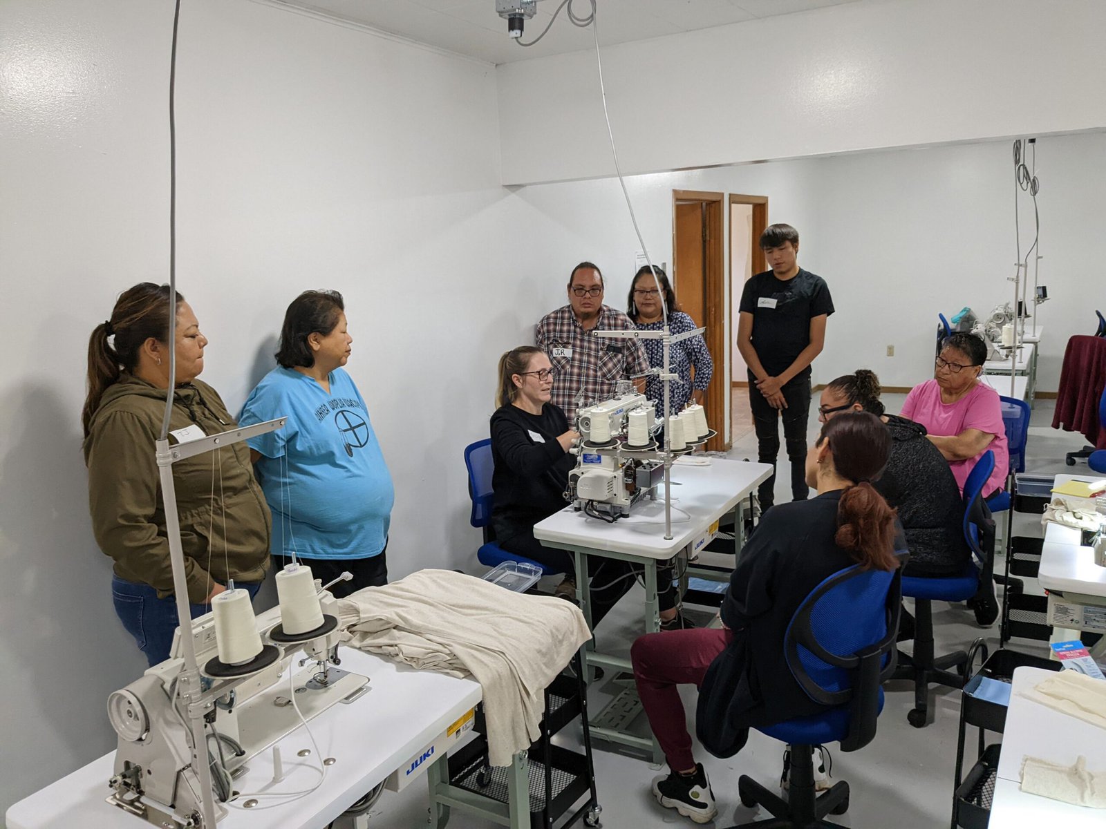 A tailor demonstrates for makers in the Oyate sewing pod.