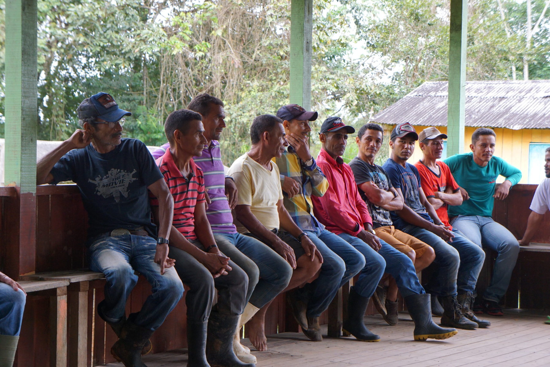 A group of men sit outside near Veja's manufacturing plant