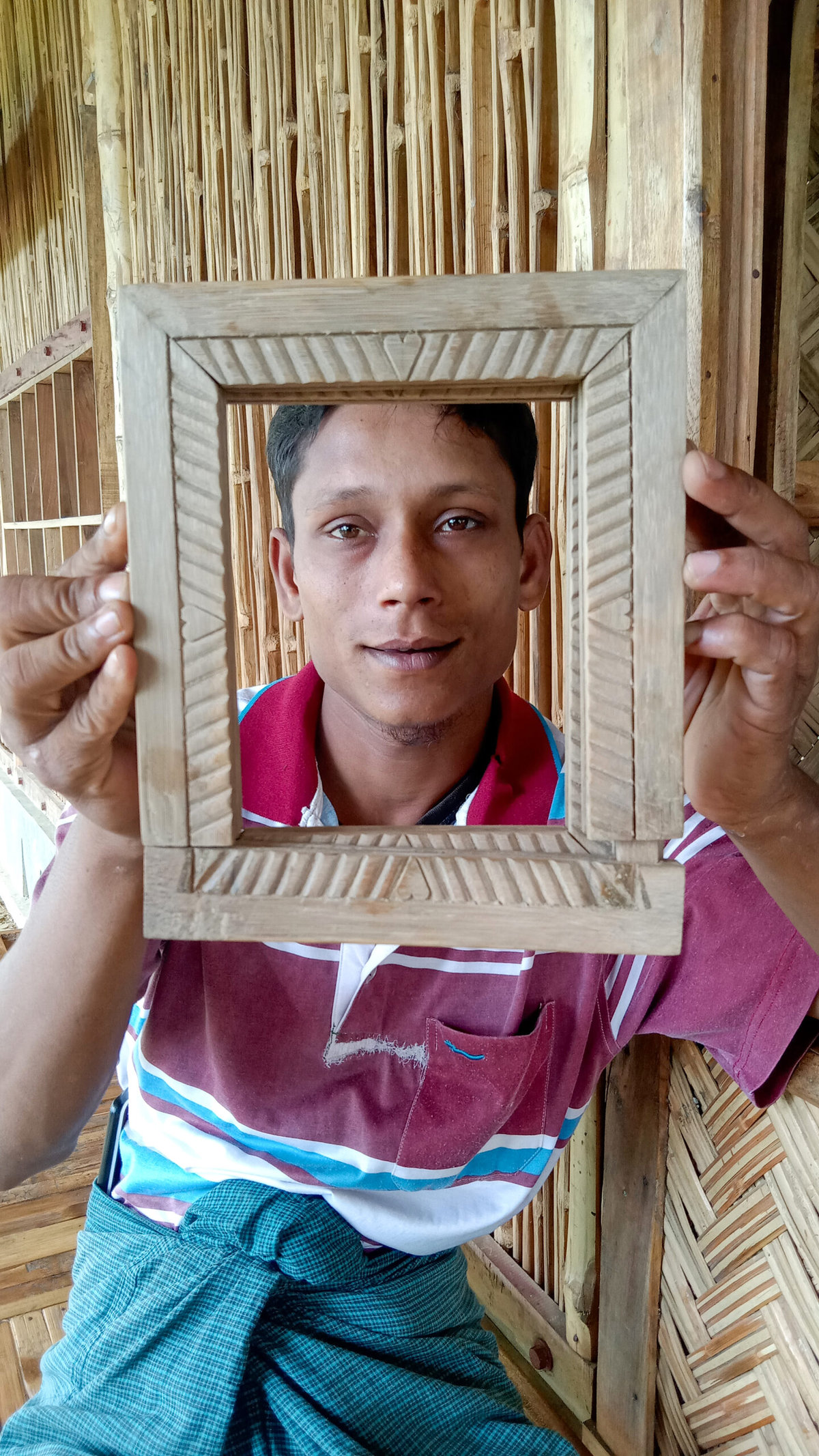 Md Hasson holds up a framed photo of himself.