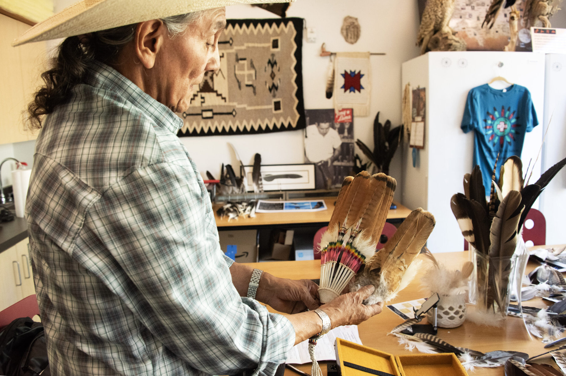 Mesta holds up a ceremonial fan and explains how a mature red-tailed hawk tail is transformed into a fan. 