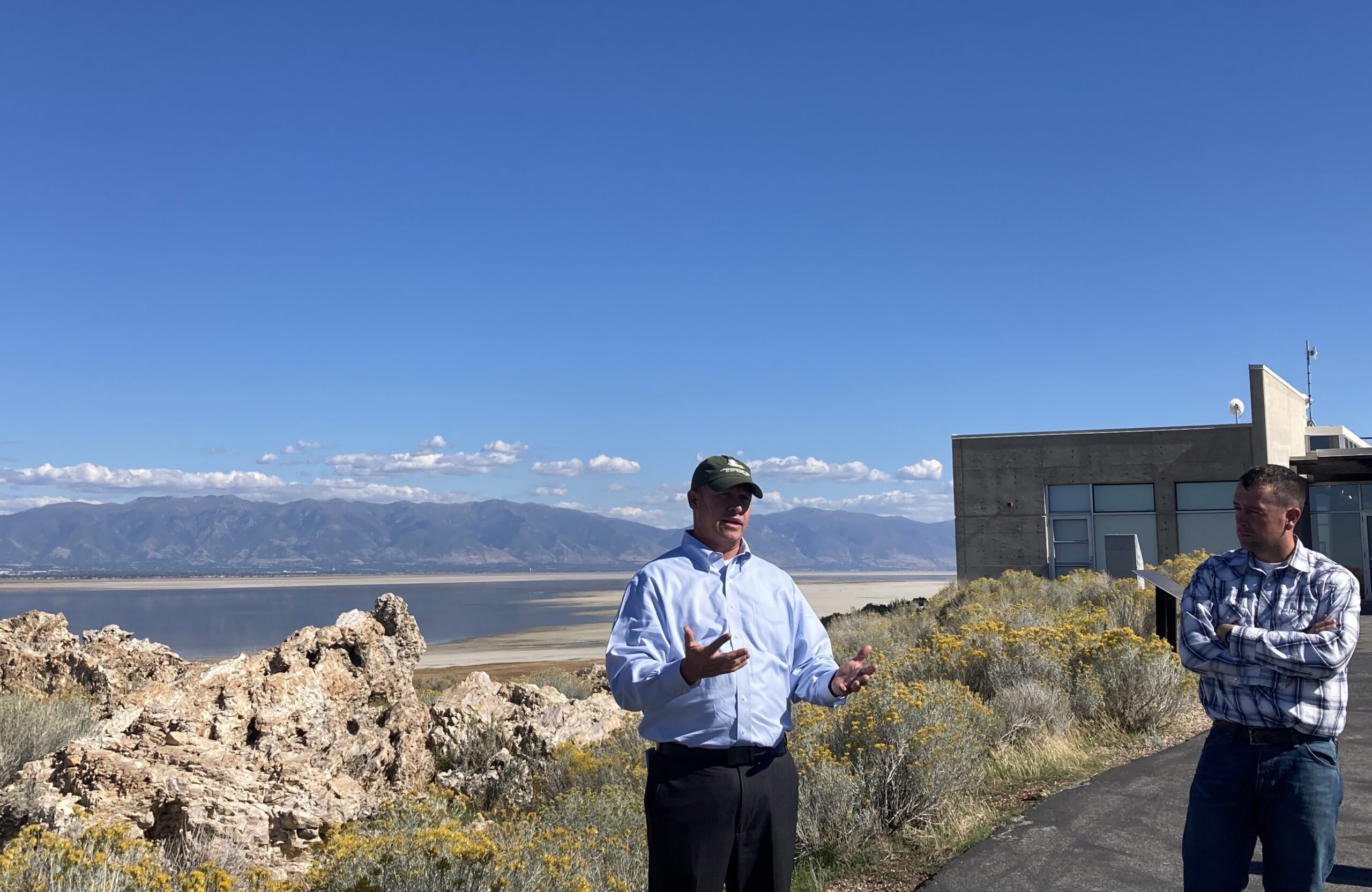Joel Ferry speaks to a group at Antelope Island about water conservation. The lake is in the background with mountains.