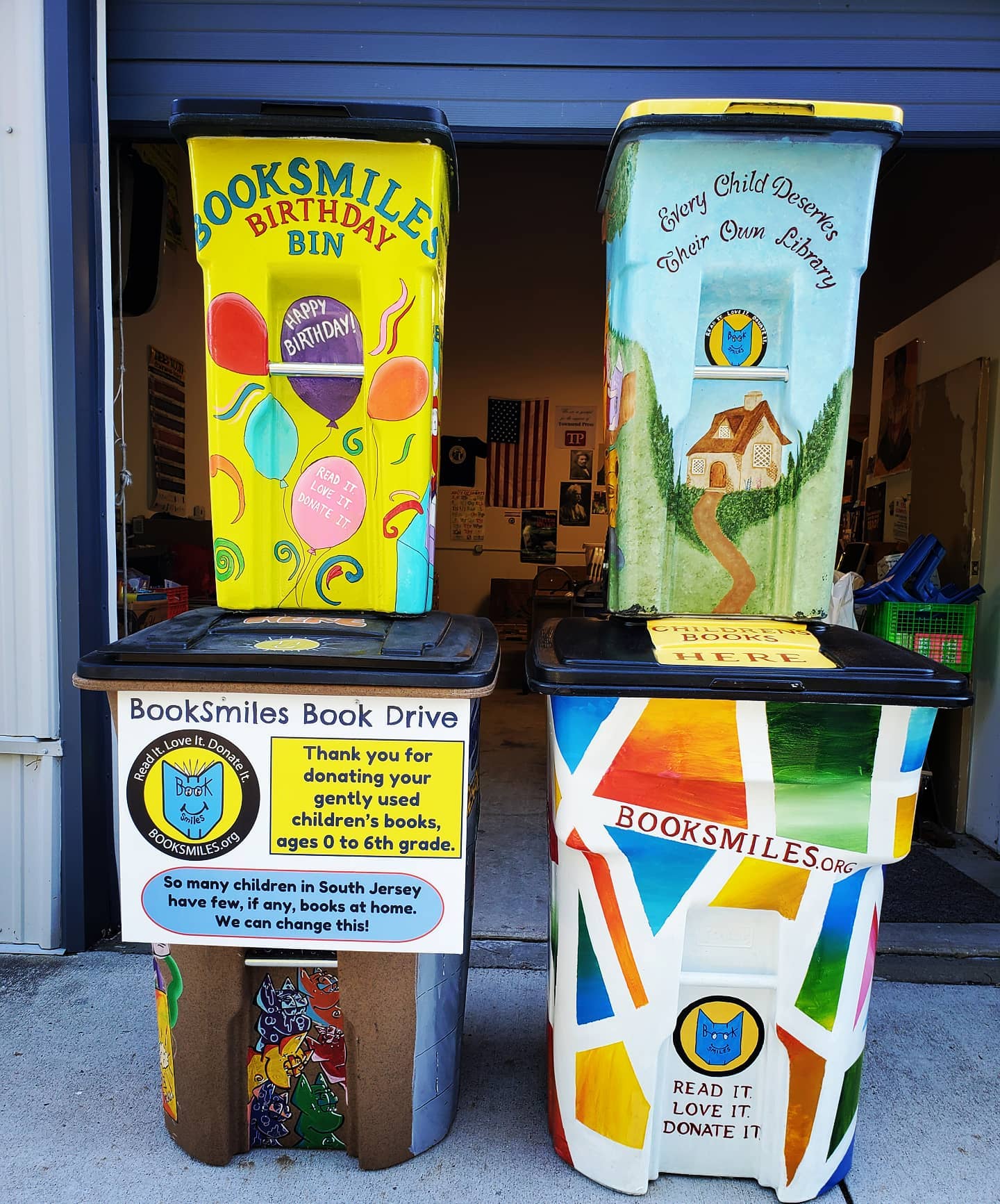 A few of BookSmiles' hand-painted book collection bins. They are colorful, stacked two by two.