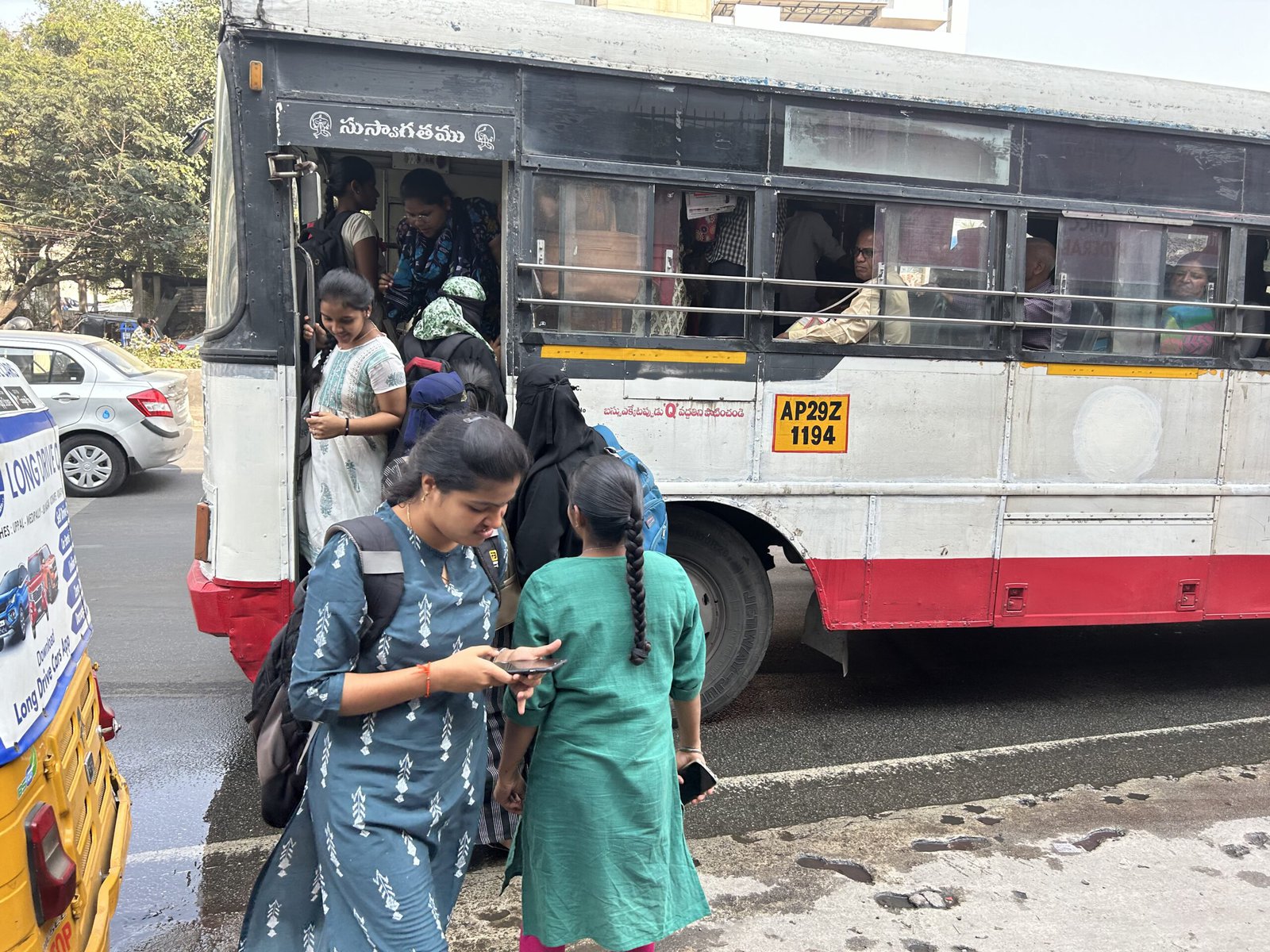 Female students boarding a bus.