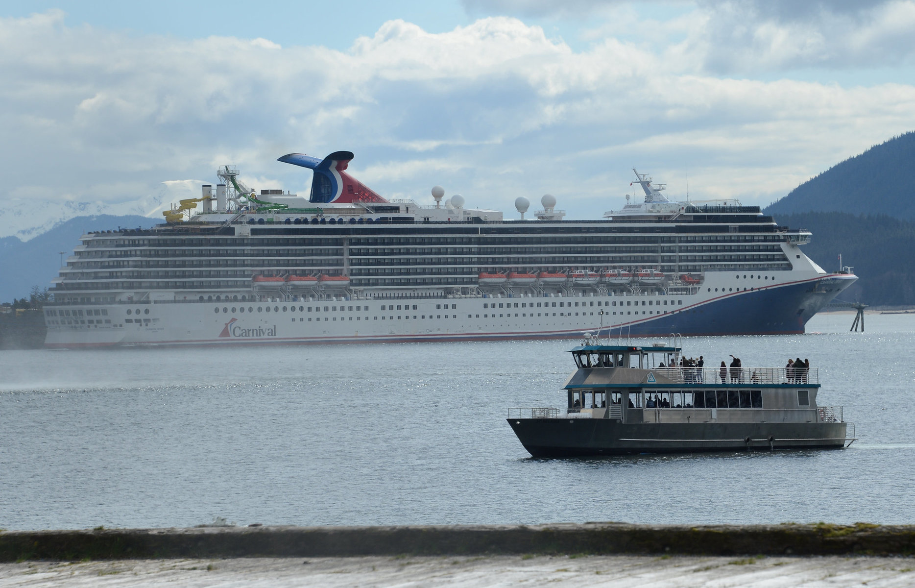An Allen Marine whale-watching boat passes in front of a Carnival Cruise Lines cruise ship in Juneau.