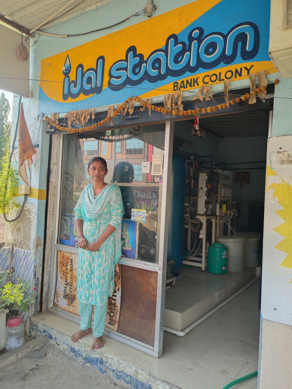 Sindhuja stands outside her water ATM station.