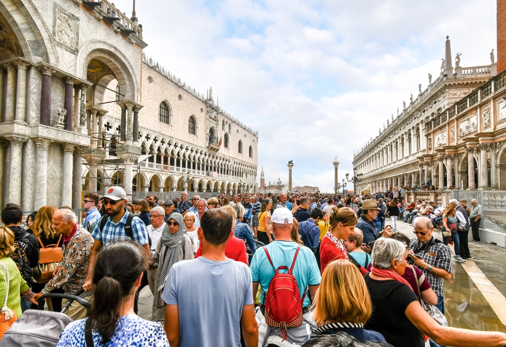 Cruise ship passengers crowd the walkway at the Doge's Palace in Piazza San Marco on a busy day in Venice.