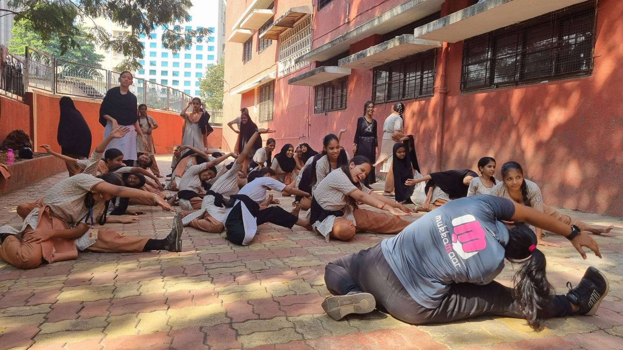 A group of girls doing stretches on a patio.