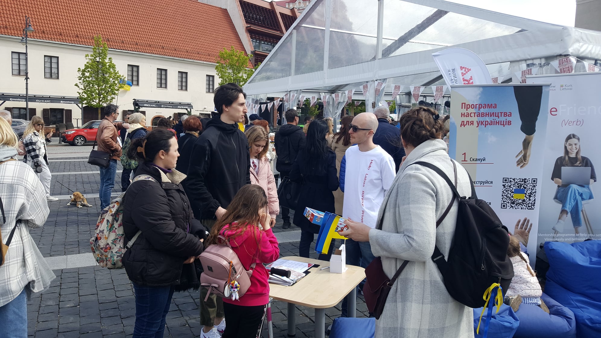 People learn about Befriend Vilnius at a table set up outside.