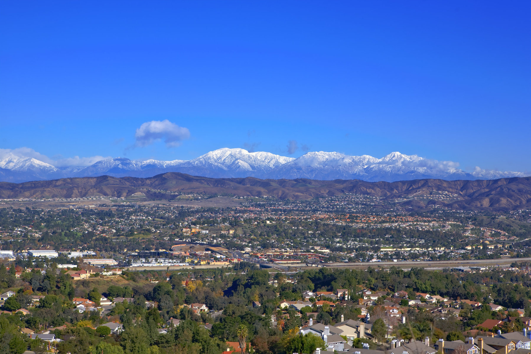 A view of Los Angeles with snowy mountains in the background.
