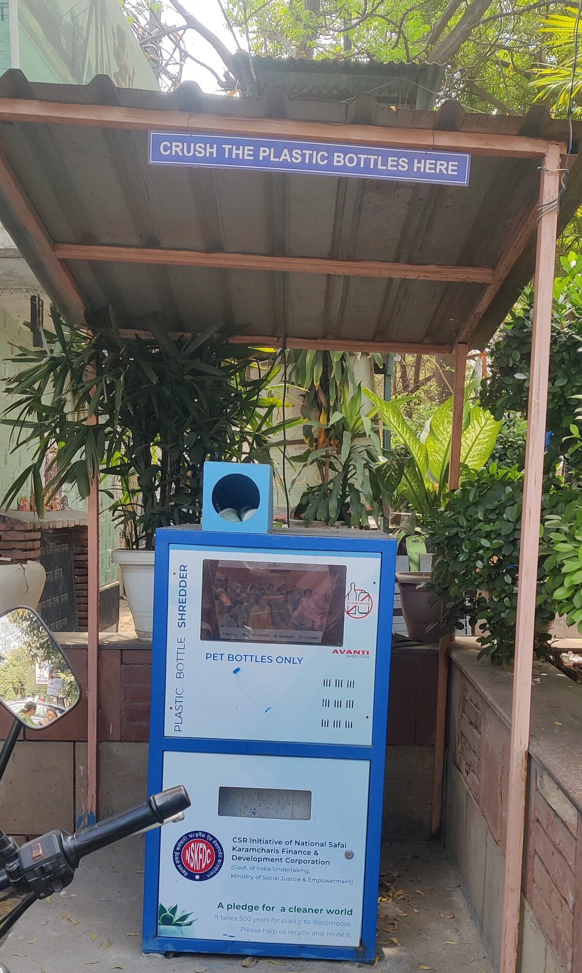 A plastic crusher machine set up outside a garbage cafe. 