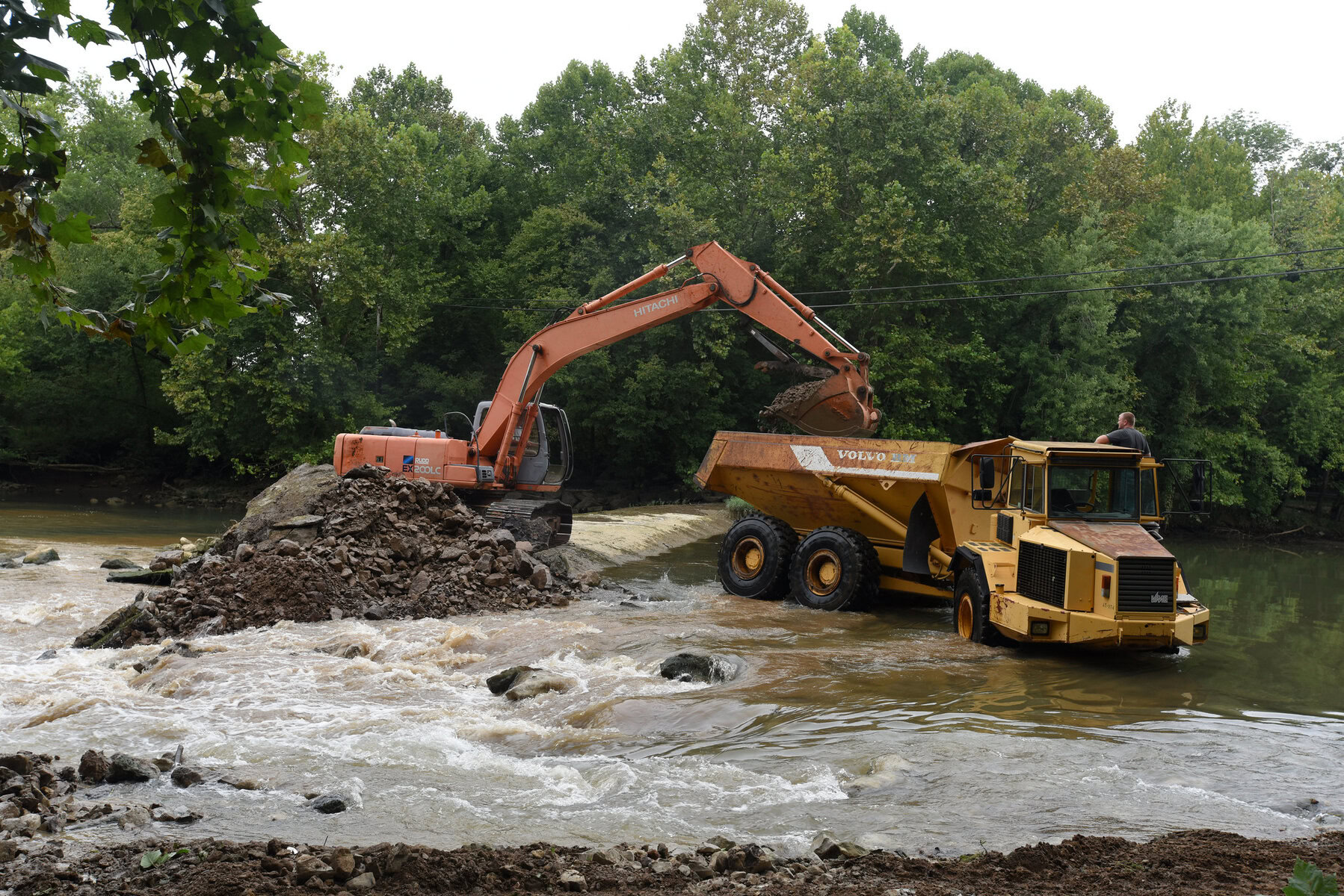 An excavator loads a dump truck with concrete, rock and soil from Roaring River Dam in Jackson County, Tennessee. 
