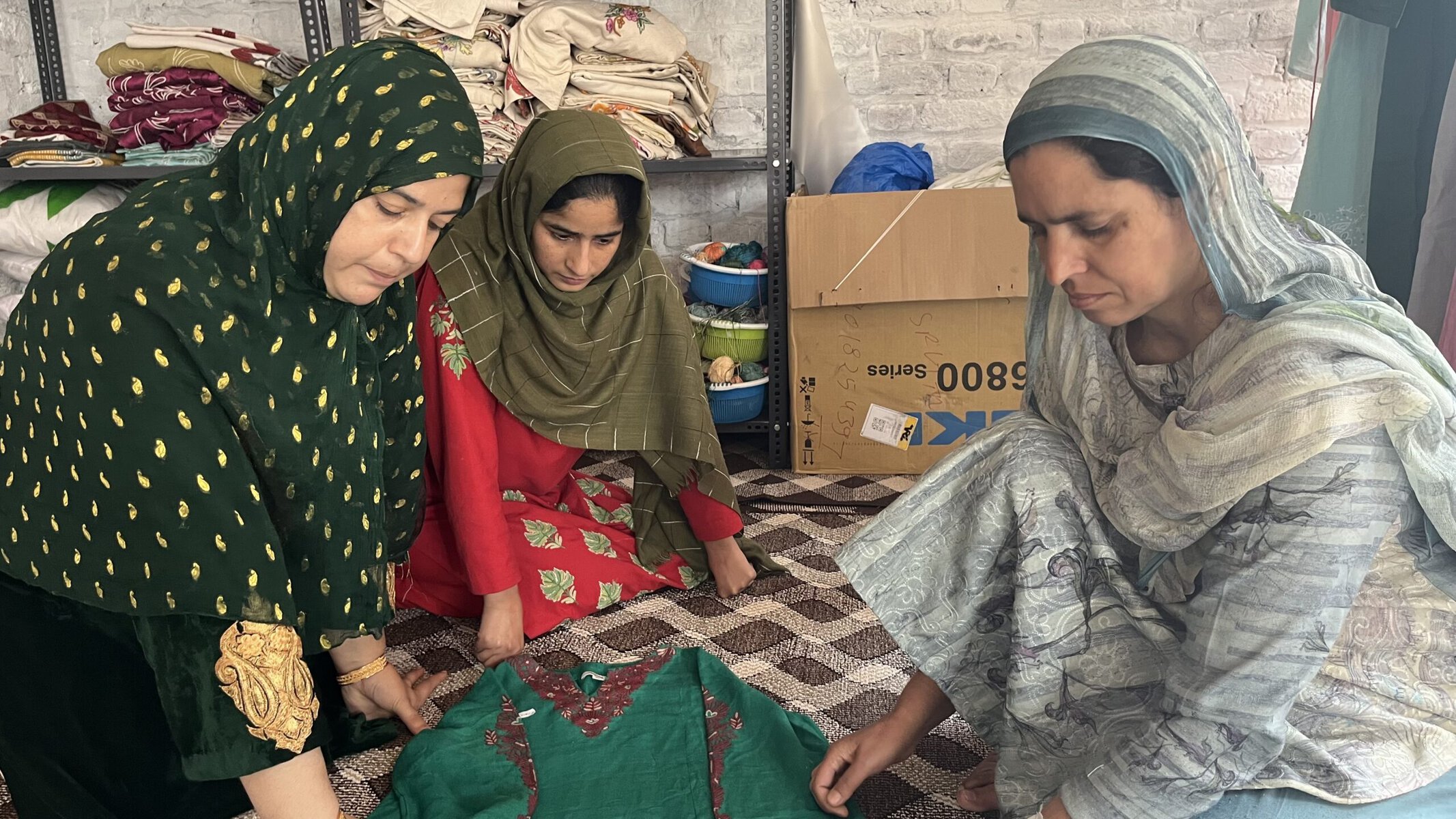 Masrat Jan (right) inspects an embroidered garment in the Noorari workshop.