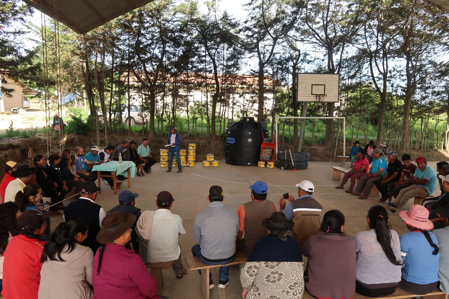A community gathers to receive their incentives — fencing and water pipes — from Natura for protecting the forest.