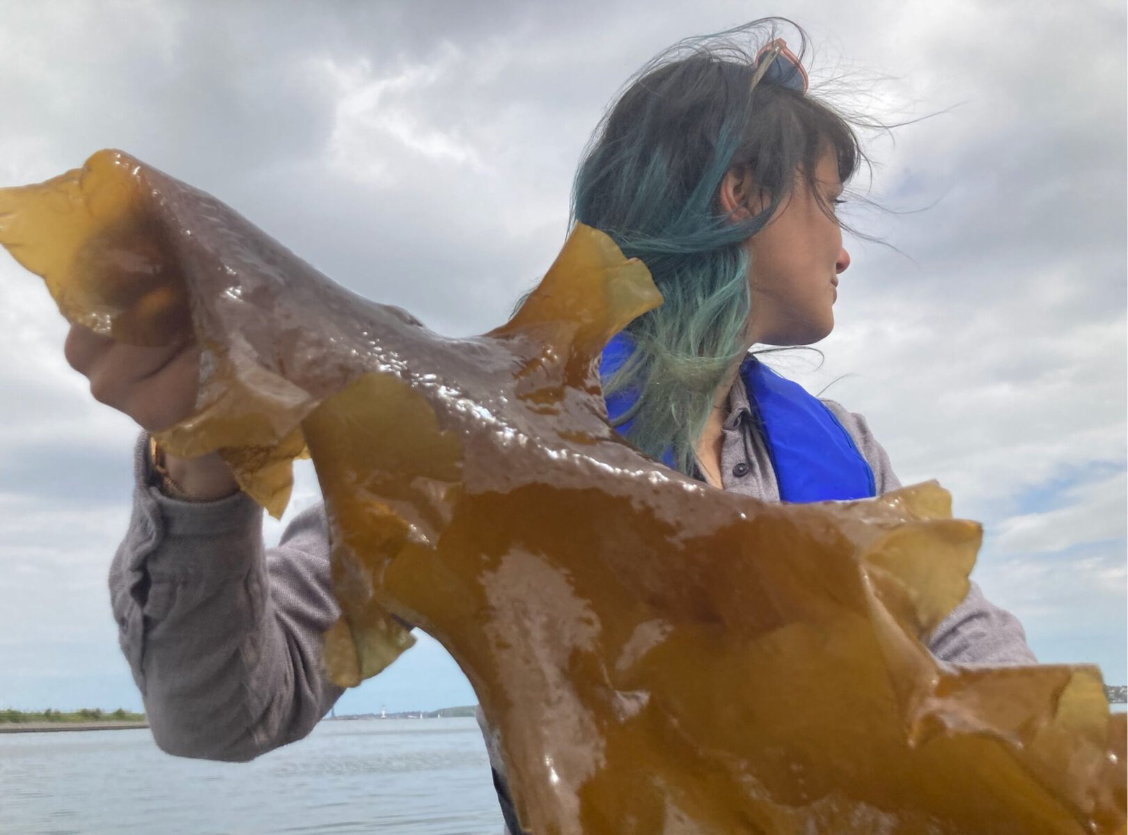 A woman holding a piece of seaweed.