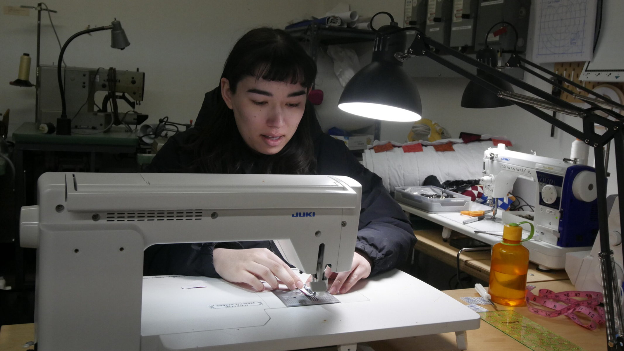 A person works on a sewing machine at Past Lives makerspace.