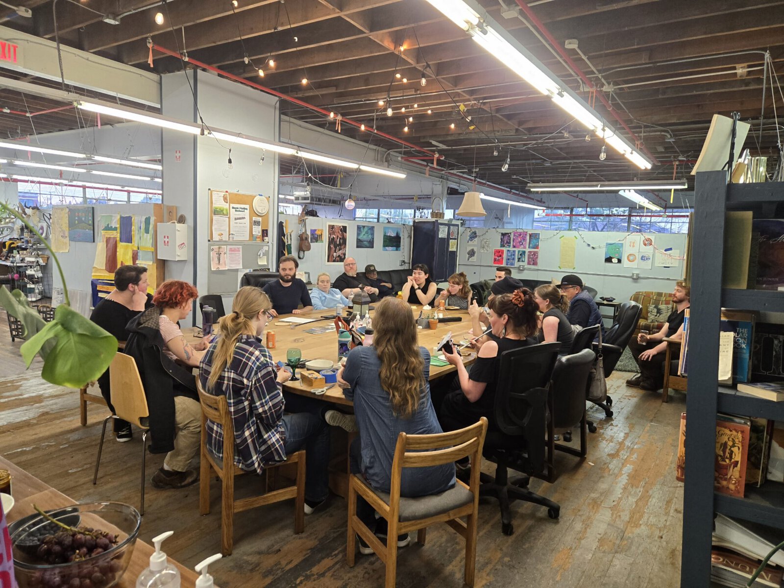 A group of makers sit together at a large table.