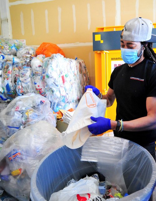 A Ridwell employee empties recyclables from a collection bag. 