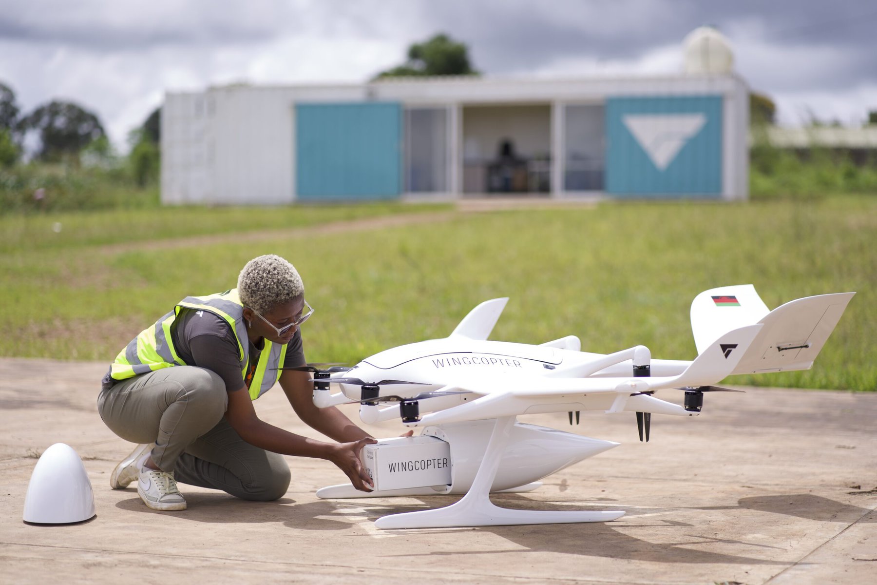 A Wingcopter technician loads a delivery into a drone.