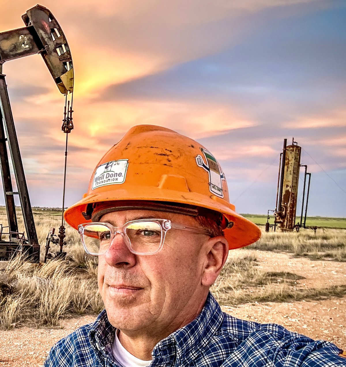 Curtis Shuck stands in front of an abandoned oil well.