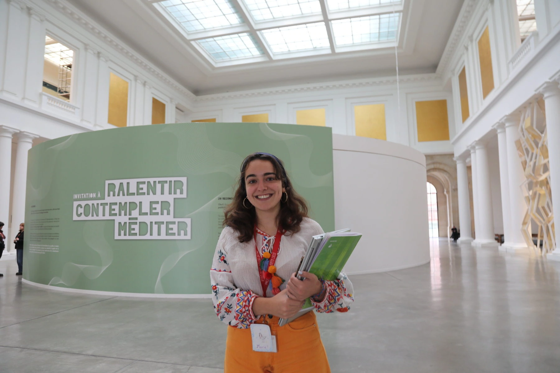 Marie Vidal de la Blache poses in front of an exhibition sign in the museum.