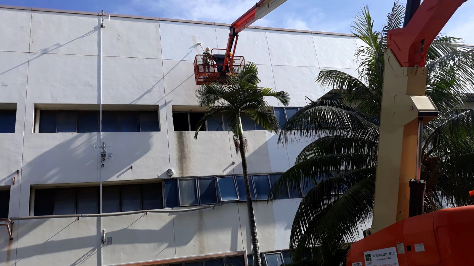 A worker sprays a coat of cool paint on the roof of a building at the test site in Singapore.