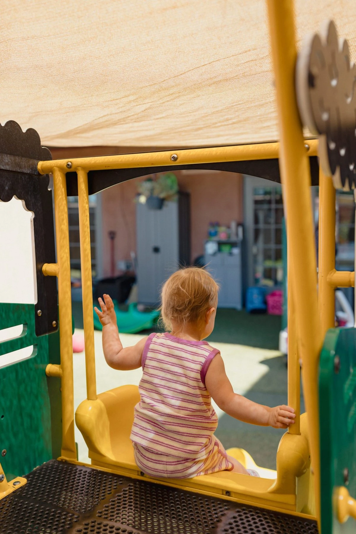 A student goes down a slide in the playground.