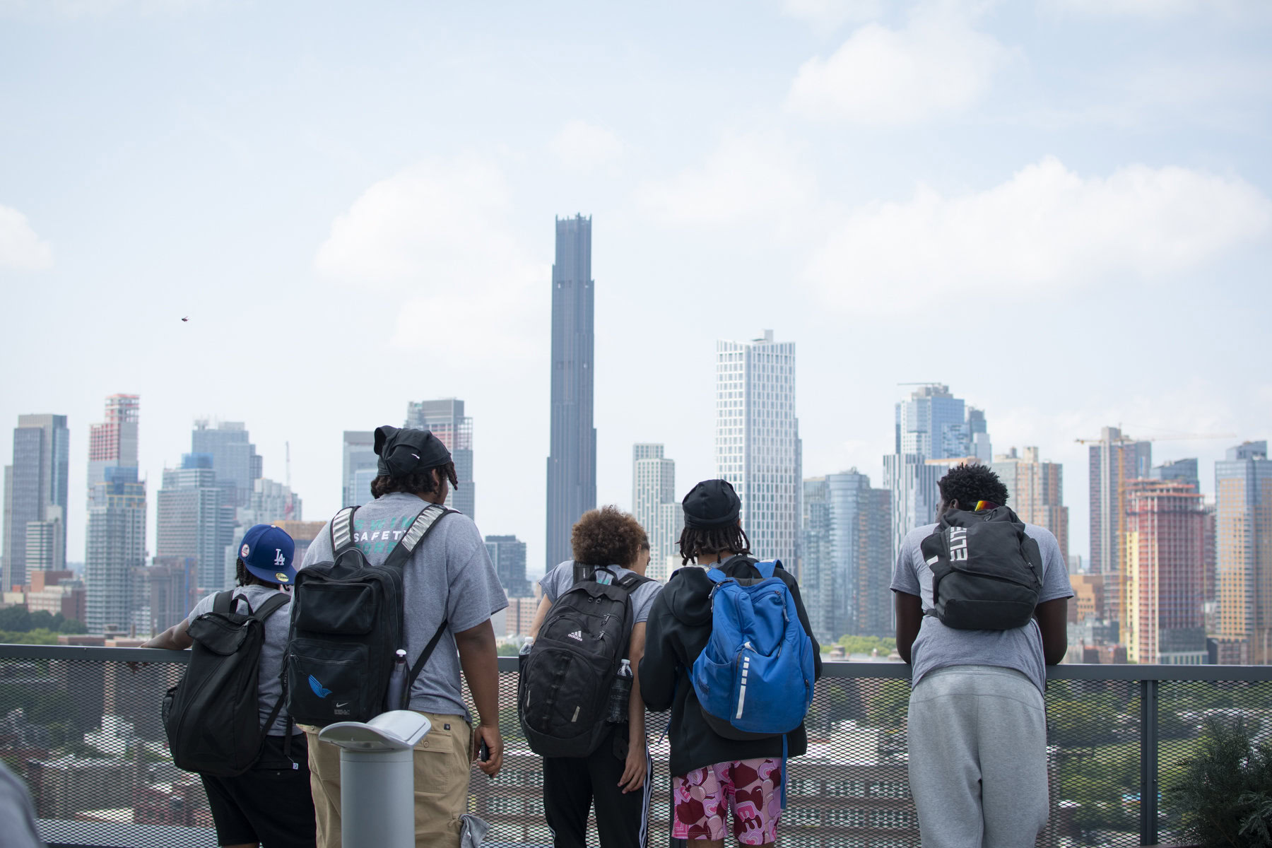 A group of Swim Corps participants look at New York City’s skyline from the balcony of Dock 72, an office building in the Brooklyn Navy Yard.