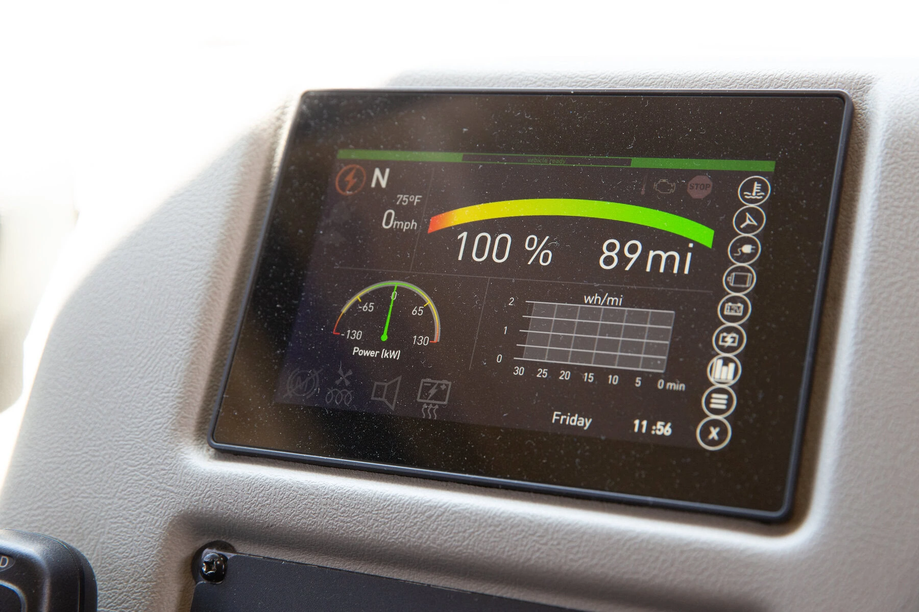 The dashboard of an electric school bus shows a full charge and a range of 89 miles.