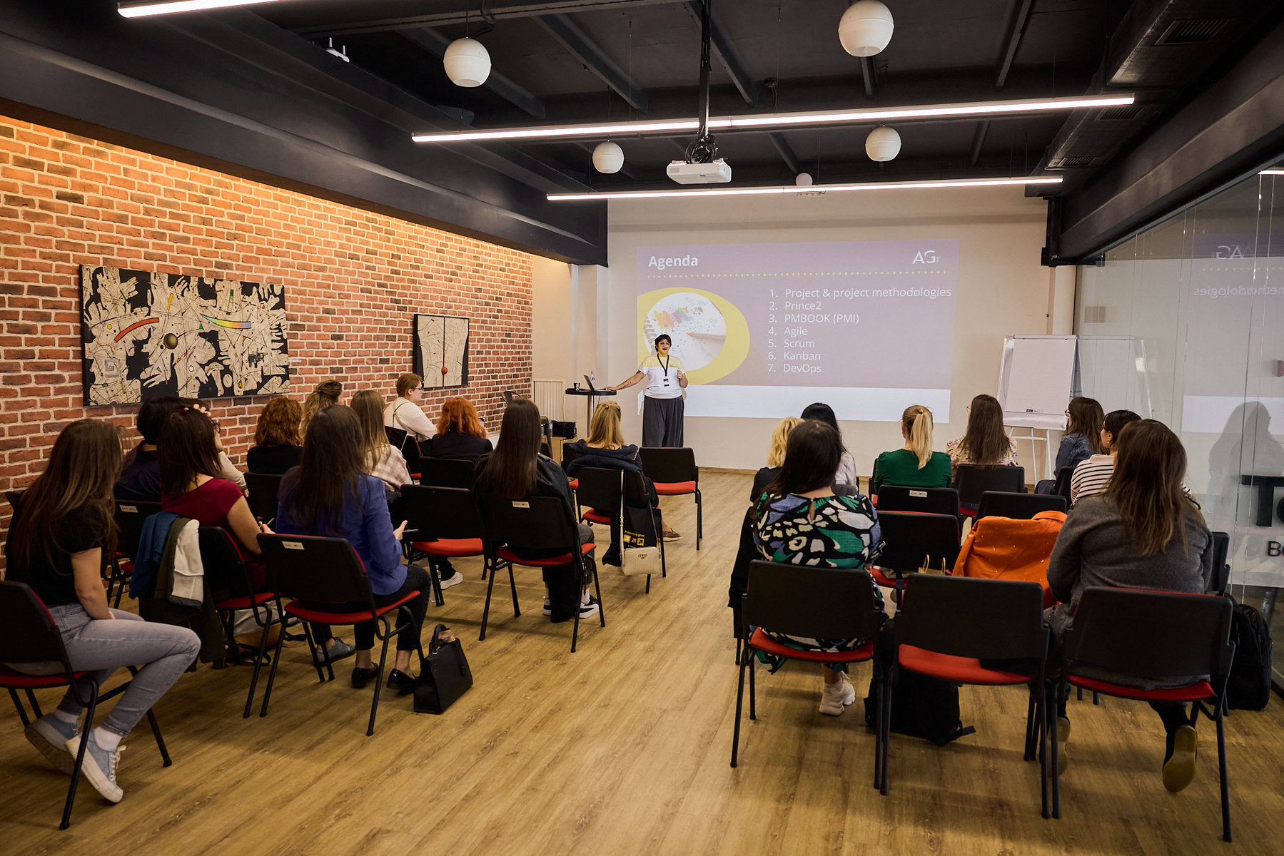 Women watch a presentation about tech careers.