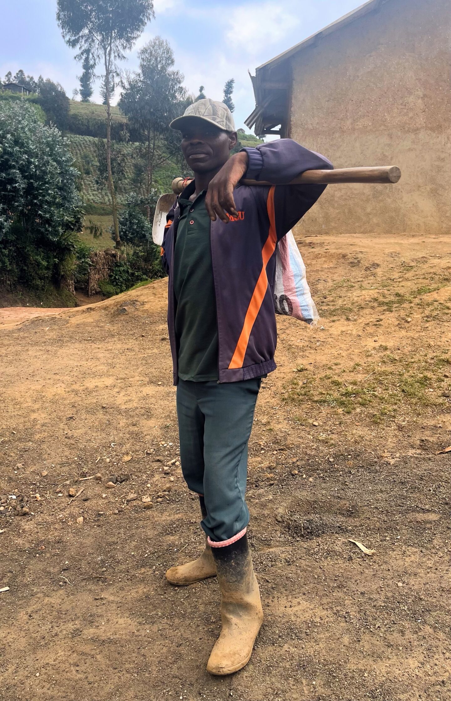 Zabayo Hategekimana poses with a large tool behind his head.