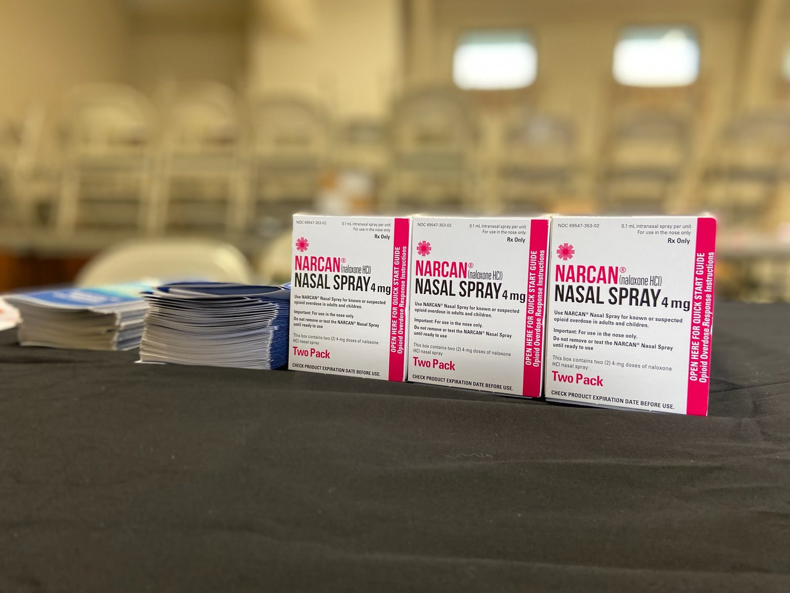 Boxes of naloxone and pamphlets on a black table cloth.