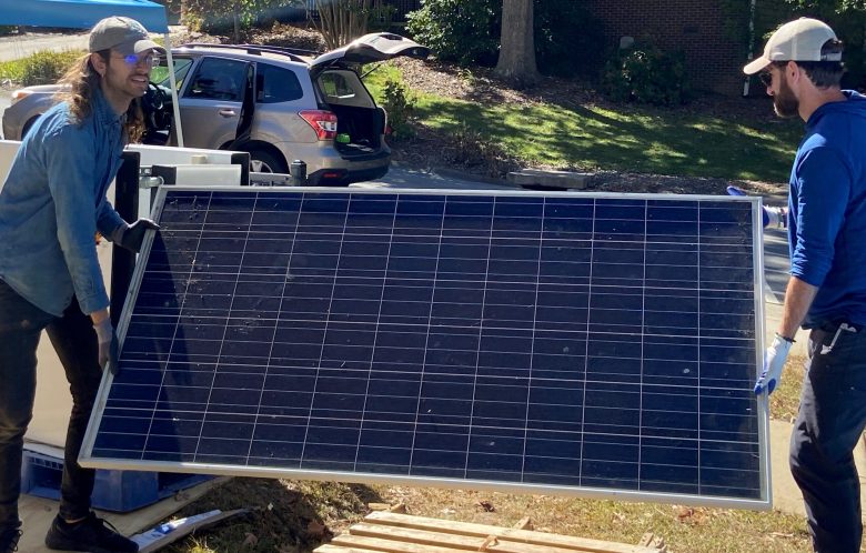 Nick Boyd, left, and Blake Davis unload solar panels in Asheville, North Carolina.