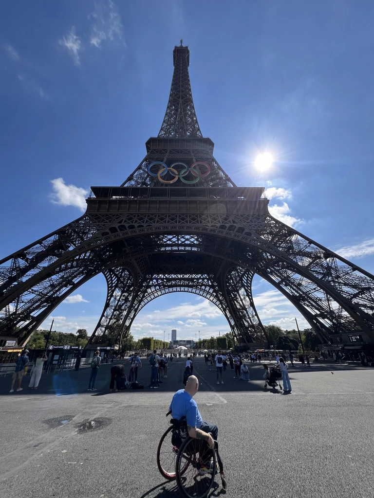 In Paris, Tongeadmires the Eiffel Tower from a wheelchair.