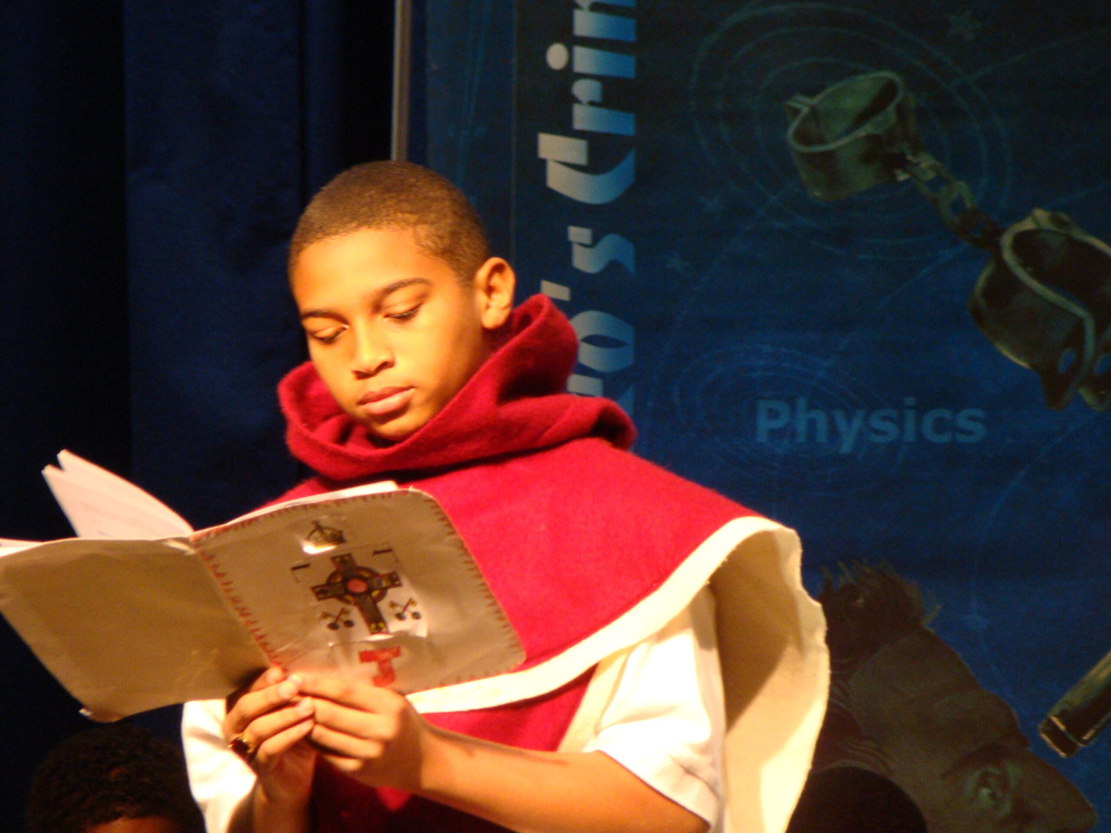 A student in costume reads from a script.