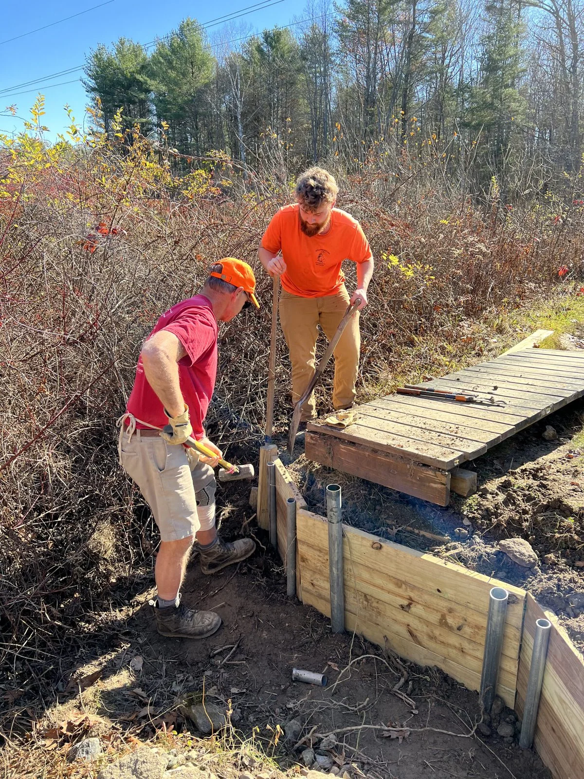 Volunteers work on a wooden trail.