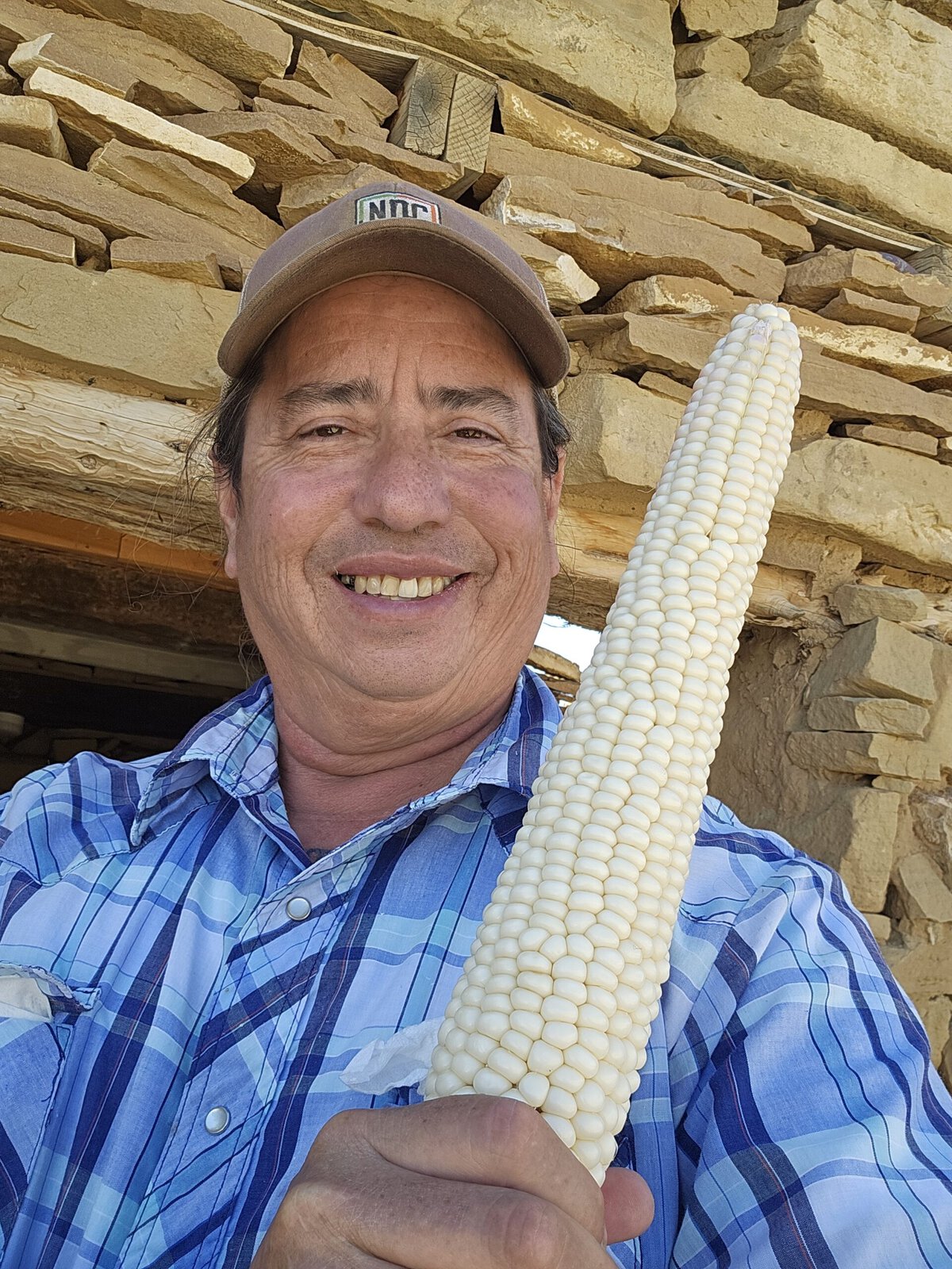 Kotutwa Johnson with a harvested ear of Hopi white corn.