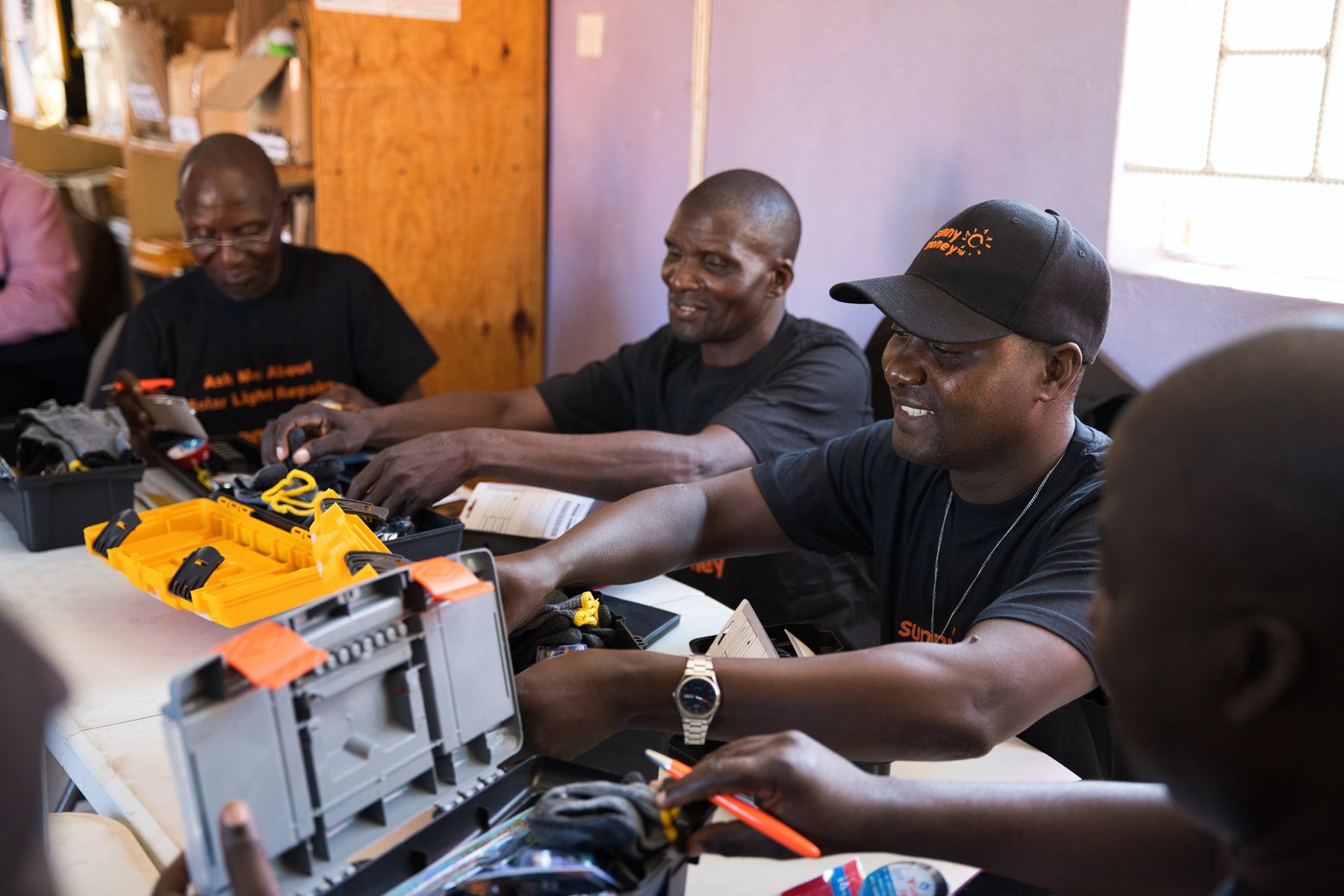 A group of people repairing solar devices.