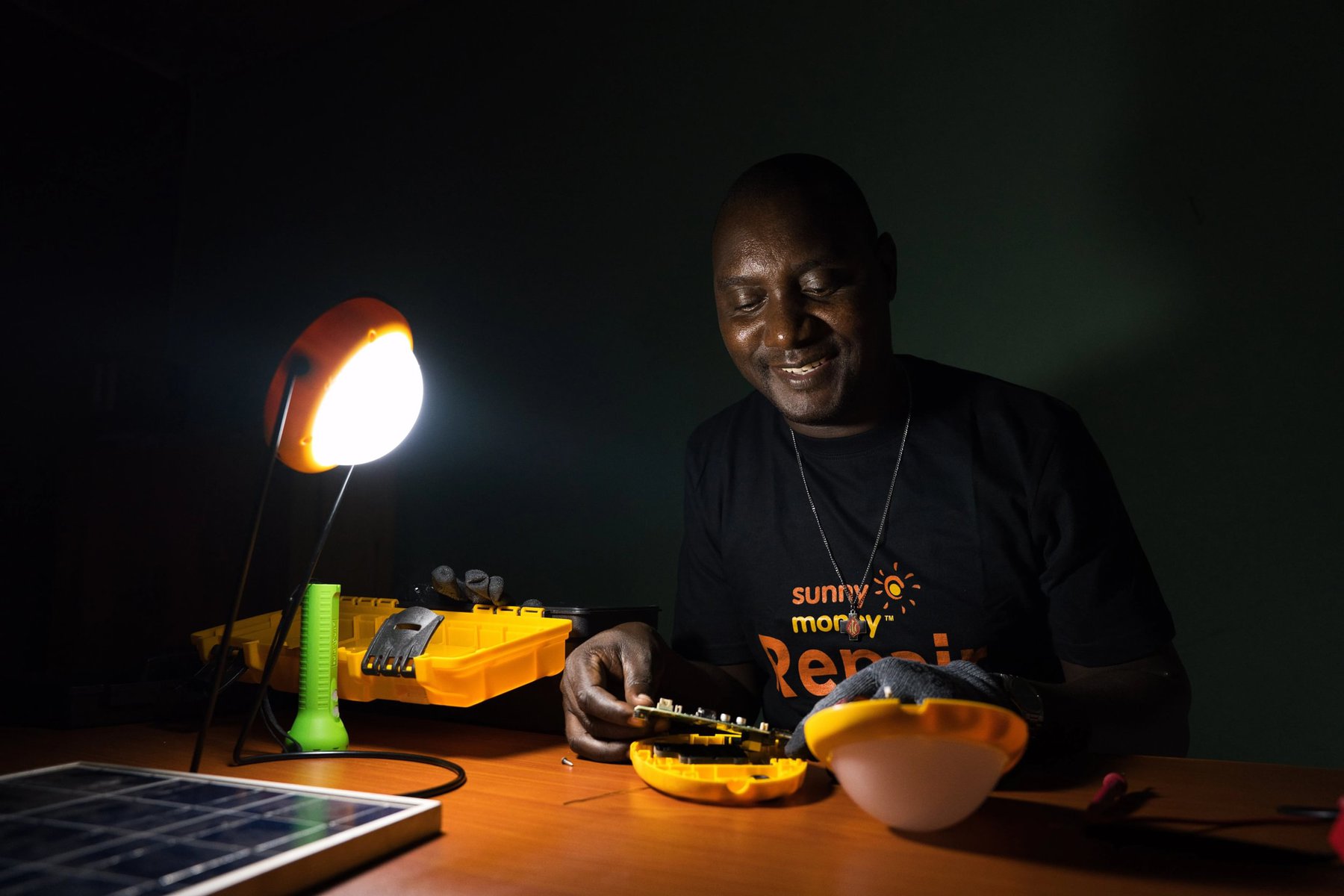 A man repairing a solar device with tools.