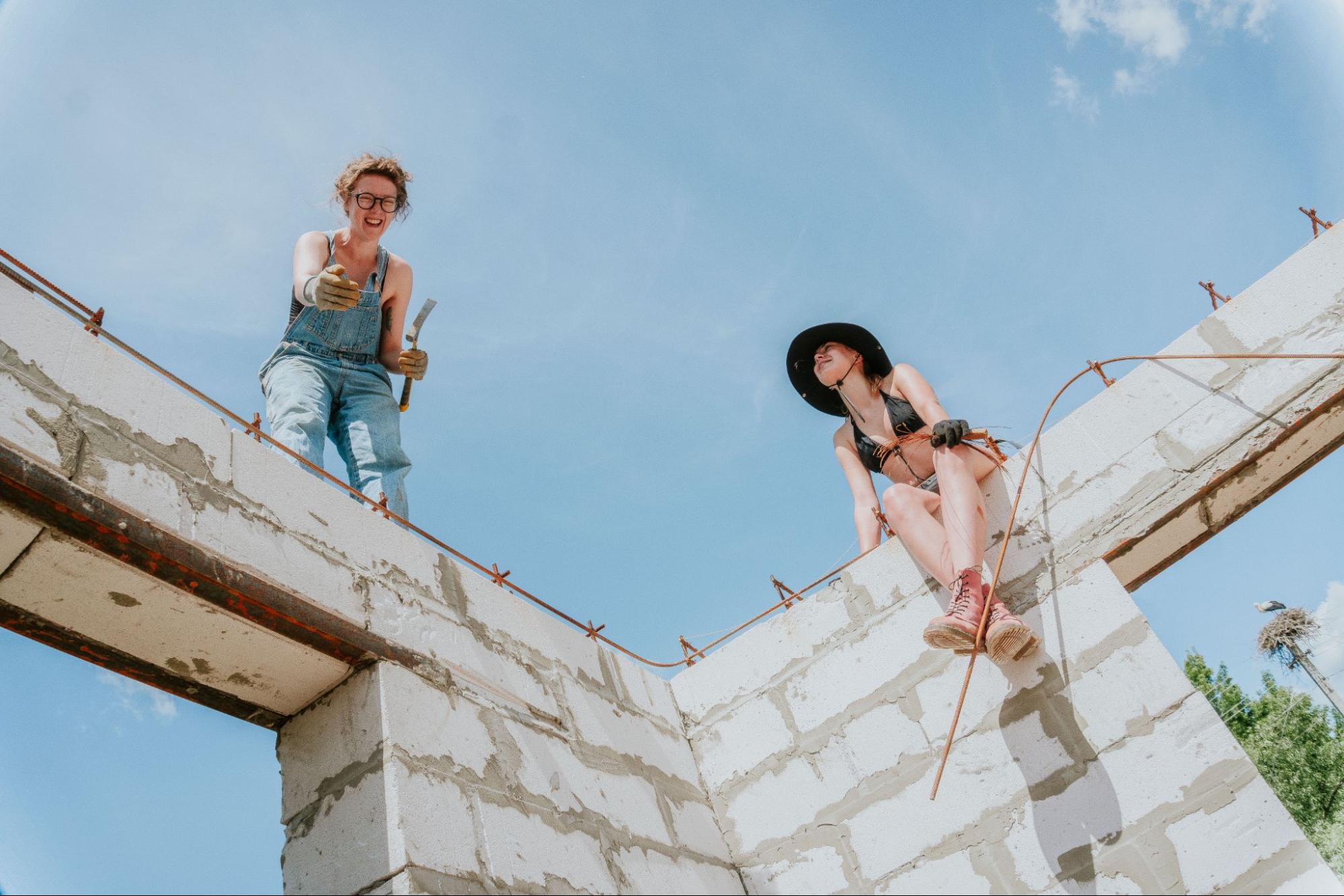 Volunteers from Repair Together stand atop the walls they are building.