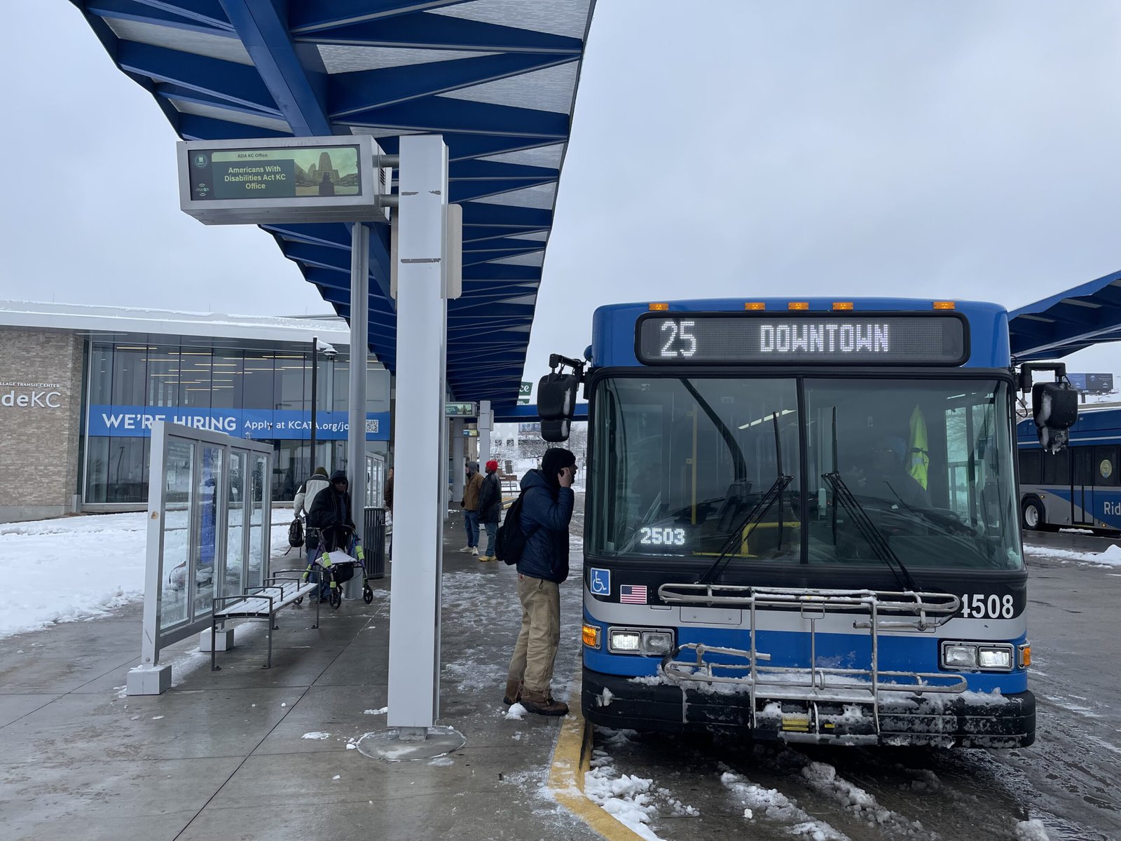 A bus at a bus stop in winter.