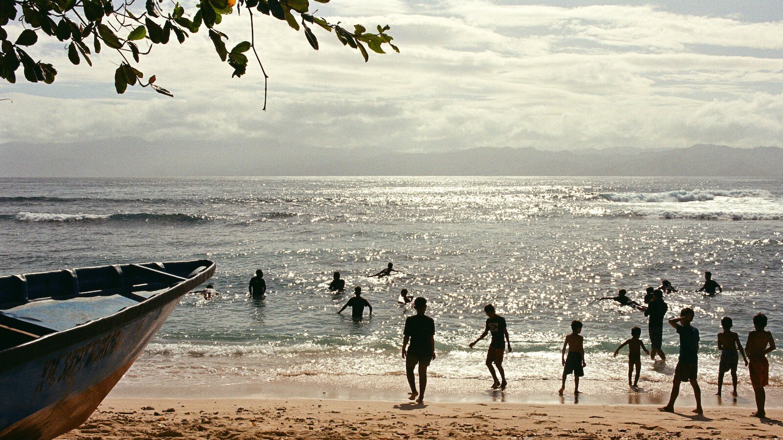 People surfing and others watching from the shore.